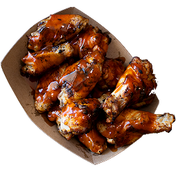 Barbecue chicken wings on a paper plate.